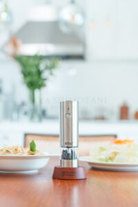 出来立ての料理と一緒にダイニングテーブルへセッティングされた、電動ミルの使用イメージ