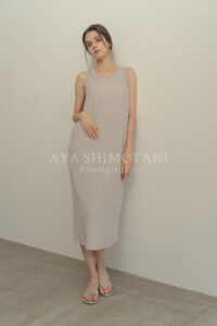 大阪のアパレル撮影カメラマンが撮影。ベージュニットワンピースの女性が壁際に立つポートレート