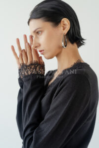 袖口の刺繍やデザインが引き立つ黒いトップスを着用したキービジュアル